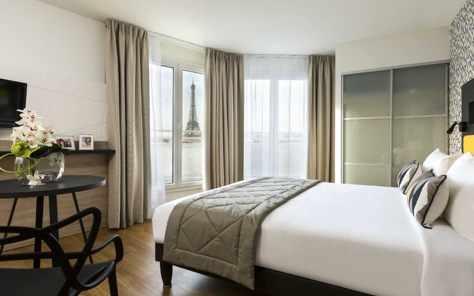 View of the top of the Eiffel tower from a bed in Citadines Tour Eiffel Paris