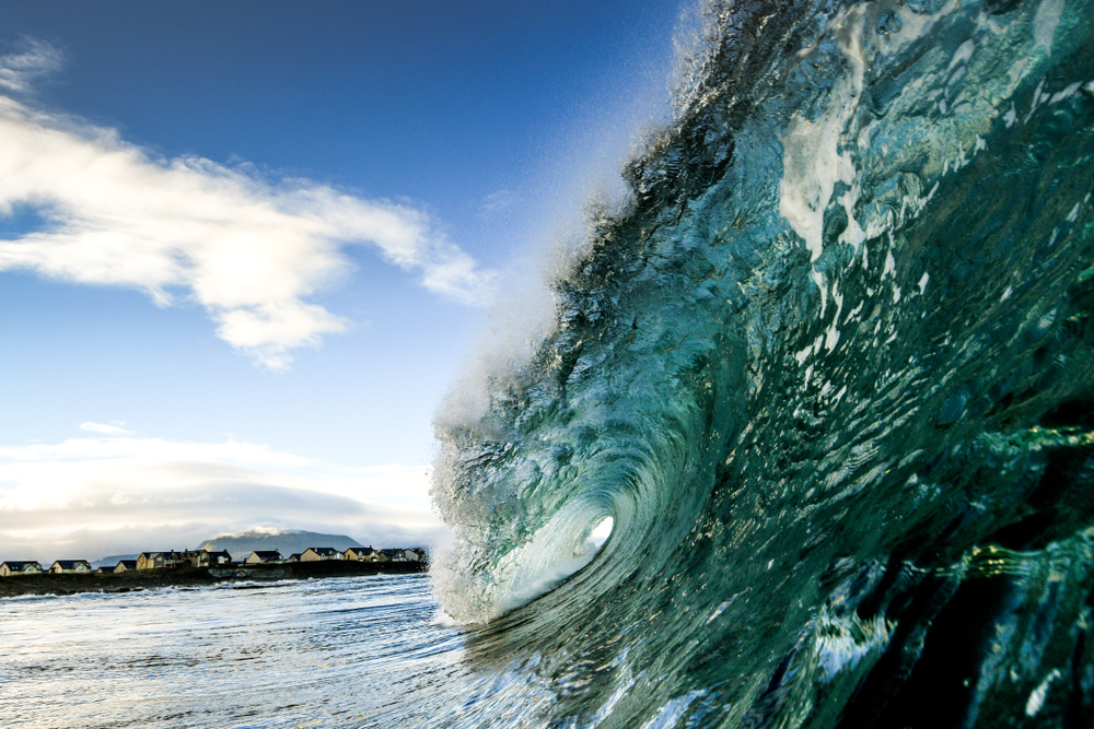 view of a crashing wave with a charming Donegal town visible in the background