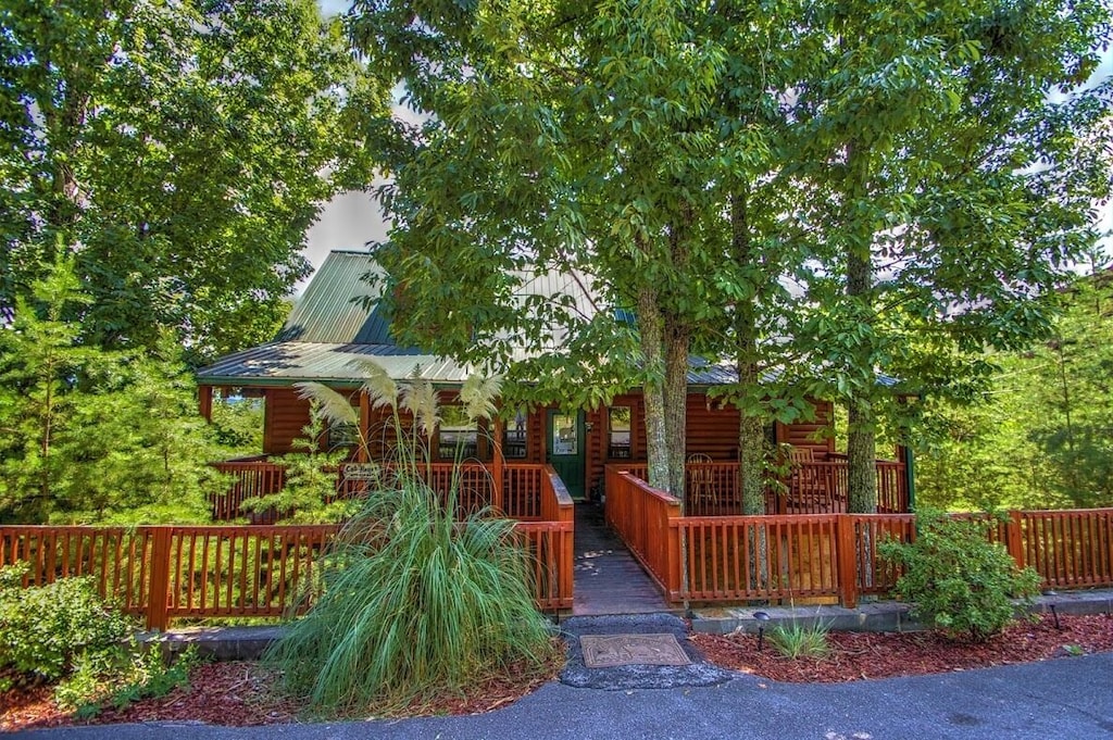 view of the outside of this cabin, nestled in the trees. This is one of the best cabins in Pigeon Forge. 