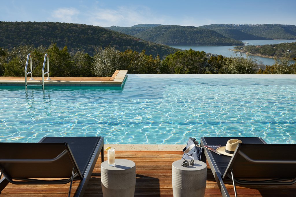 pool at miravel austin overlooking texas hill country with blue pool and lounge chairs