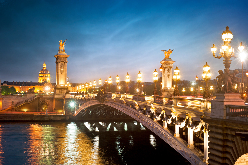 Alexandre 3 Bridge lit up at night in an article about the best time to visit Paris.  