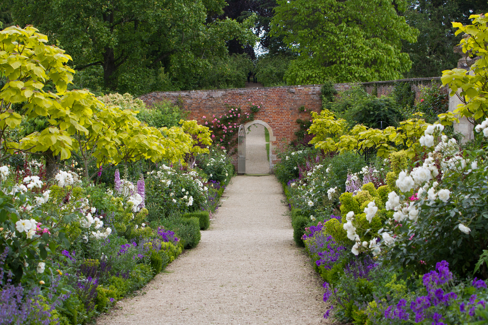 The Walled Garden at Buscot Park House, There are roses and flowers either side. 
