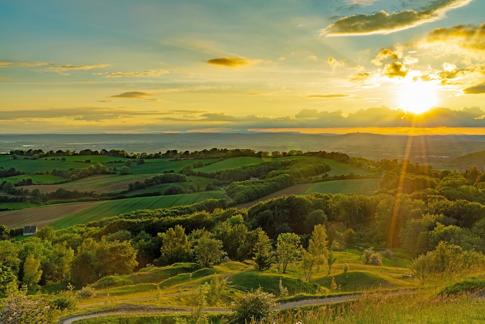 A beautiful golden sunset in spring, with lens flare, looking over the Cotswold countryside 