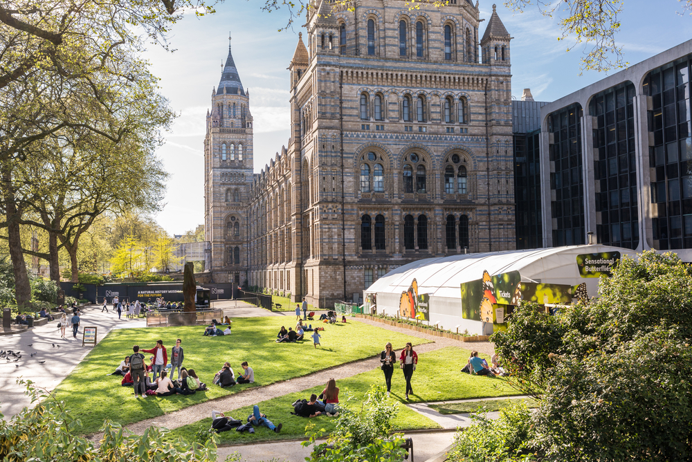 People enjoying the sunny warm day in front of the Natural History Museum, Kensington and Chelsea, London, UK.