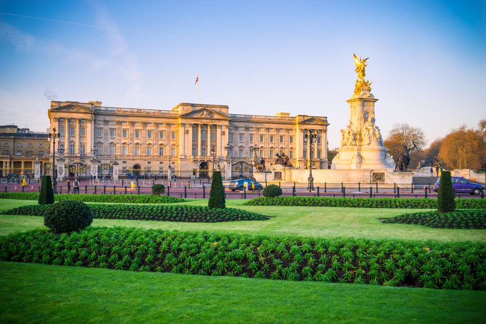 Buckingham Palace taken from the front with grass and the fountain.