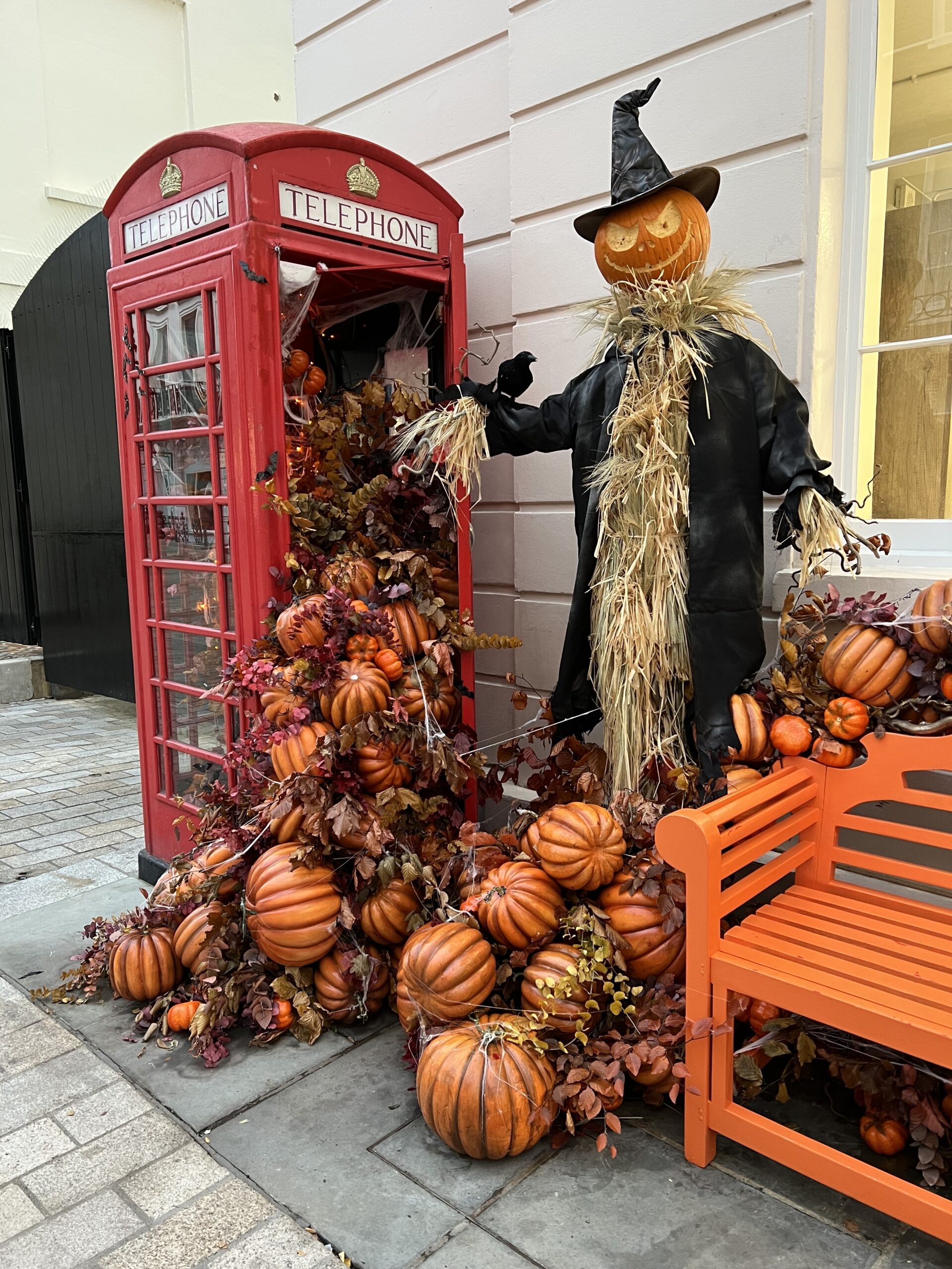 Halloween decorations in London, England. There are pumpkins coming out a telephone box onto a bench. October is the best time to visit London.
