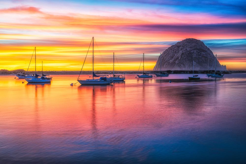 Morro Rock and boats at sunset in an article about San Francisco to Los Angeles Road Trip