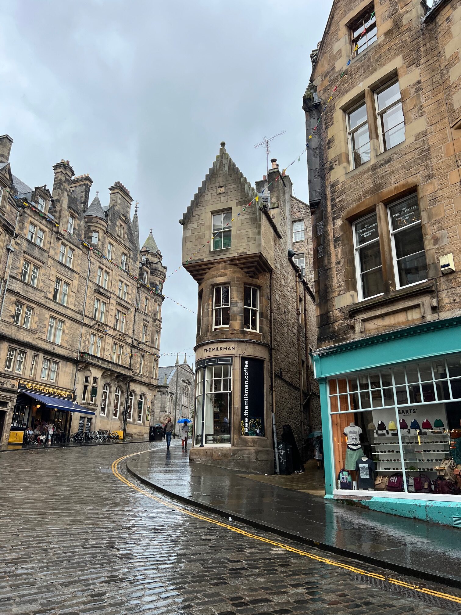 view down cockburn street in Edinburgh Scotland with rainy sky and green buildings