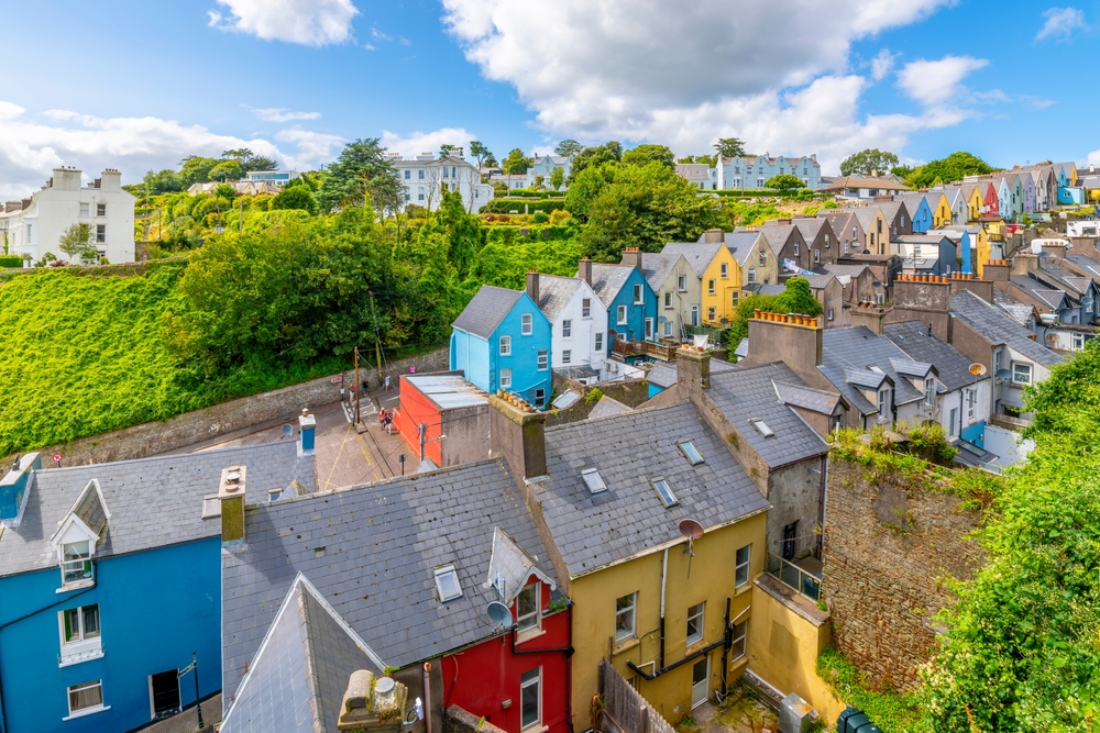 The colorful Deck of Cards, a row of brightly painted townhomes on a steep hill in the town of Cobh, Ireland, in Cork County, at summer.