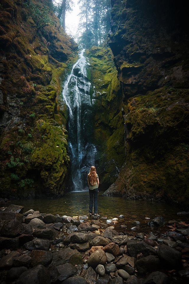 woman standing at the base of Pinard Falls in Oregon