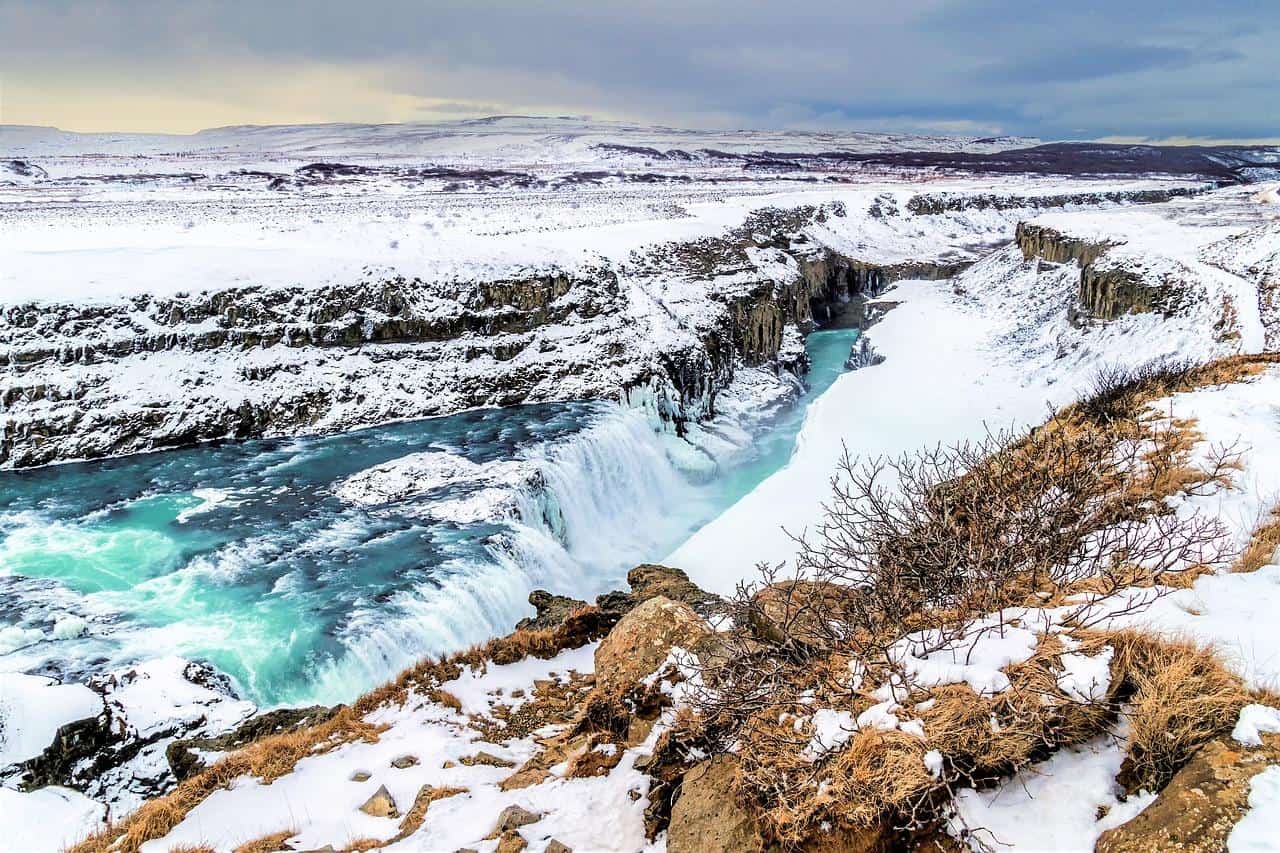 gullfoss waterfall in iceland on a cloudy winter day covered in snow