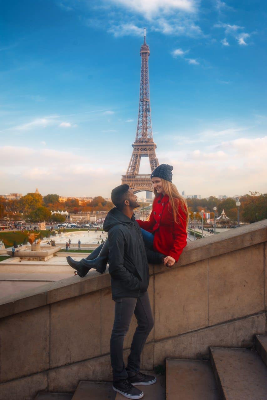 A couple in front of the Eiffel Tower dressed from winter in Paris.