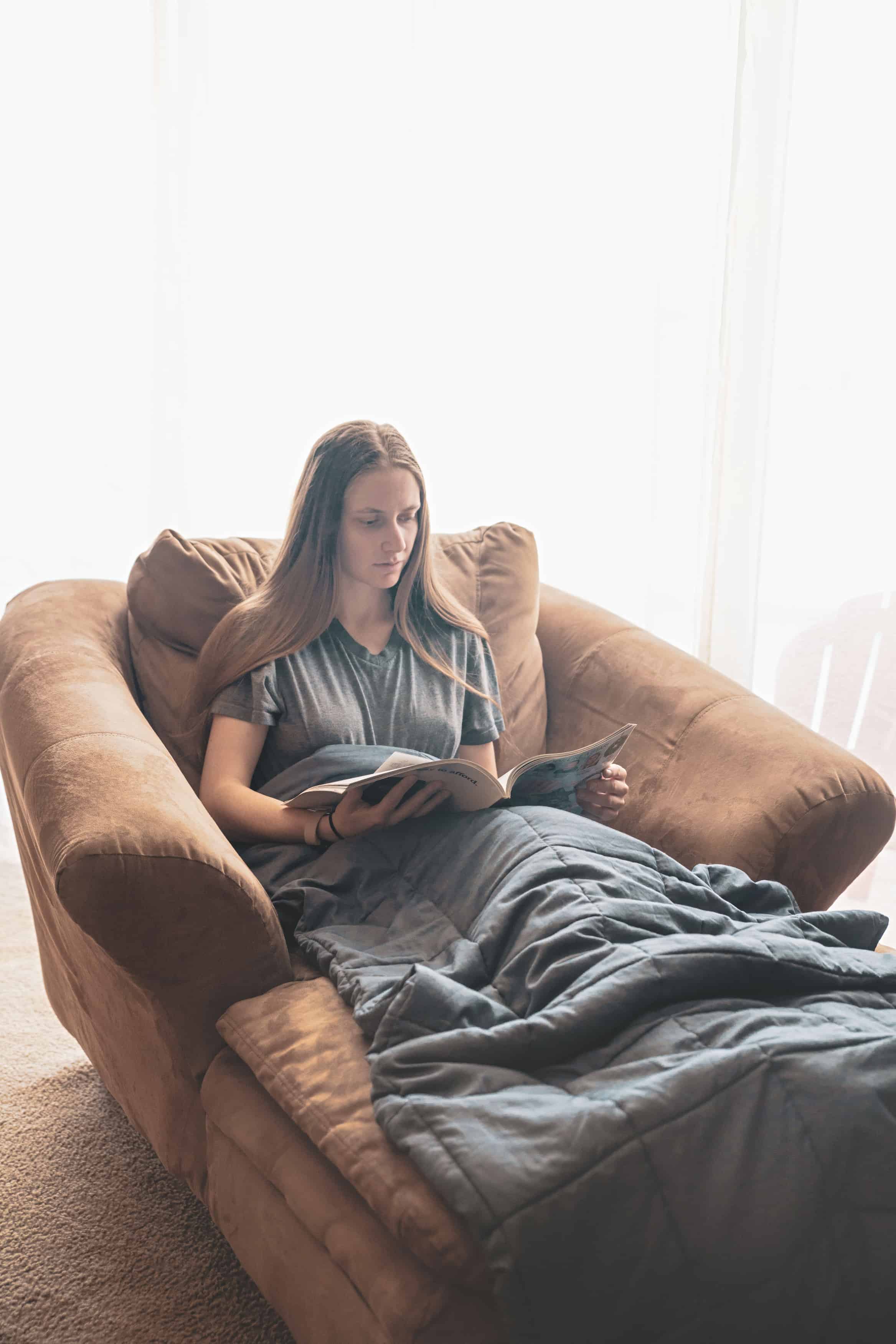 reading a book in a weighted blanket for adults