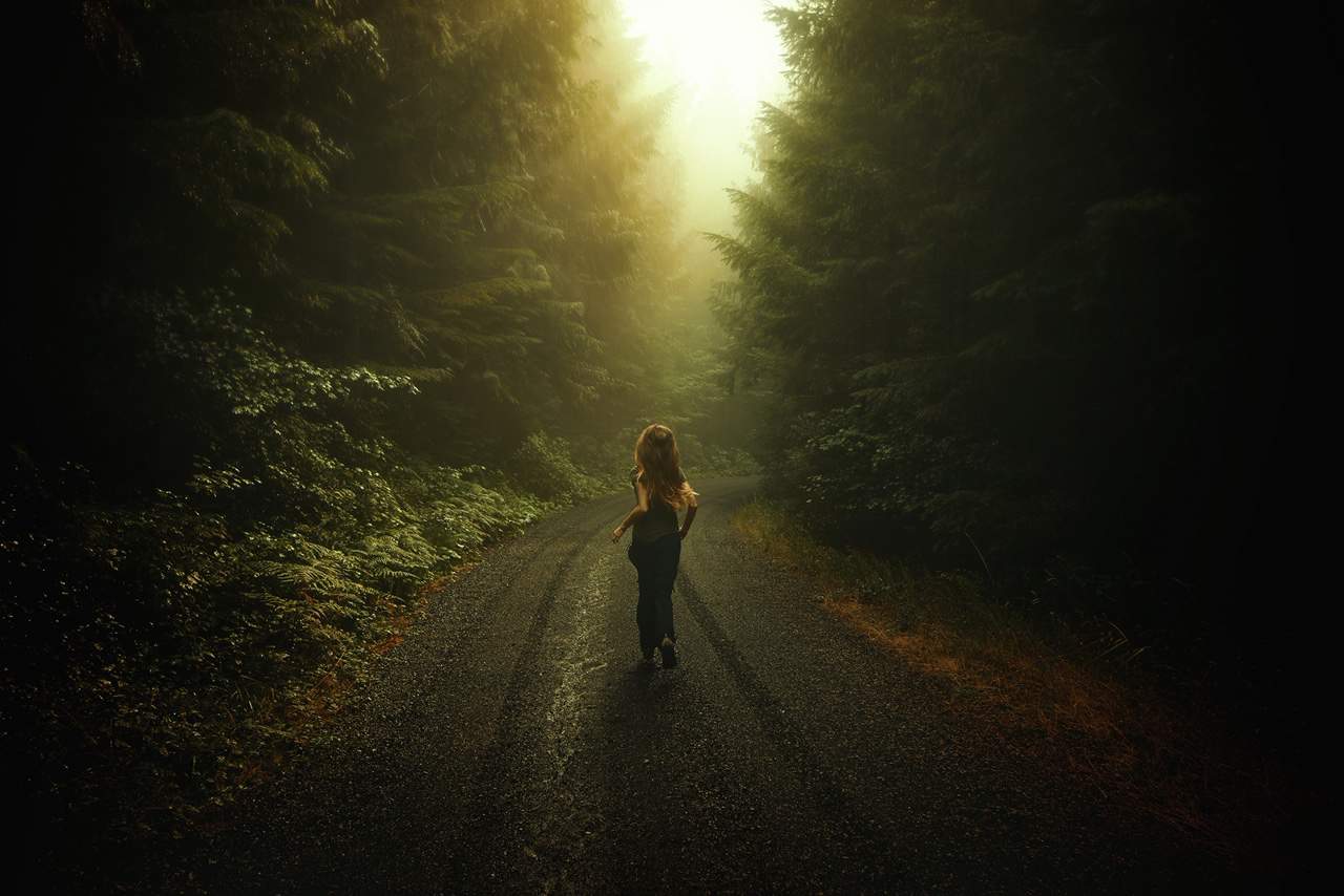 girl running down a road in oregon with light rays