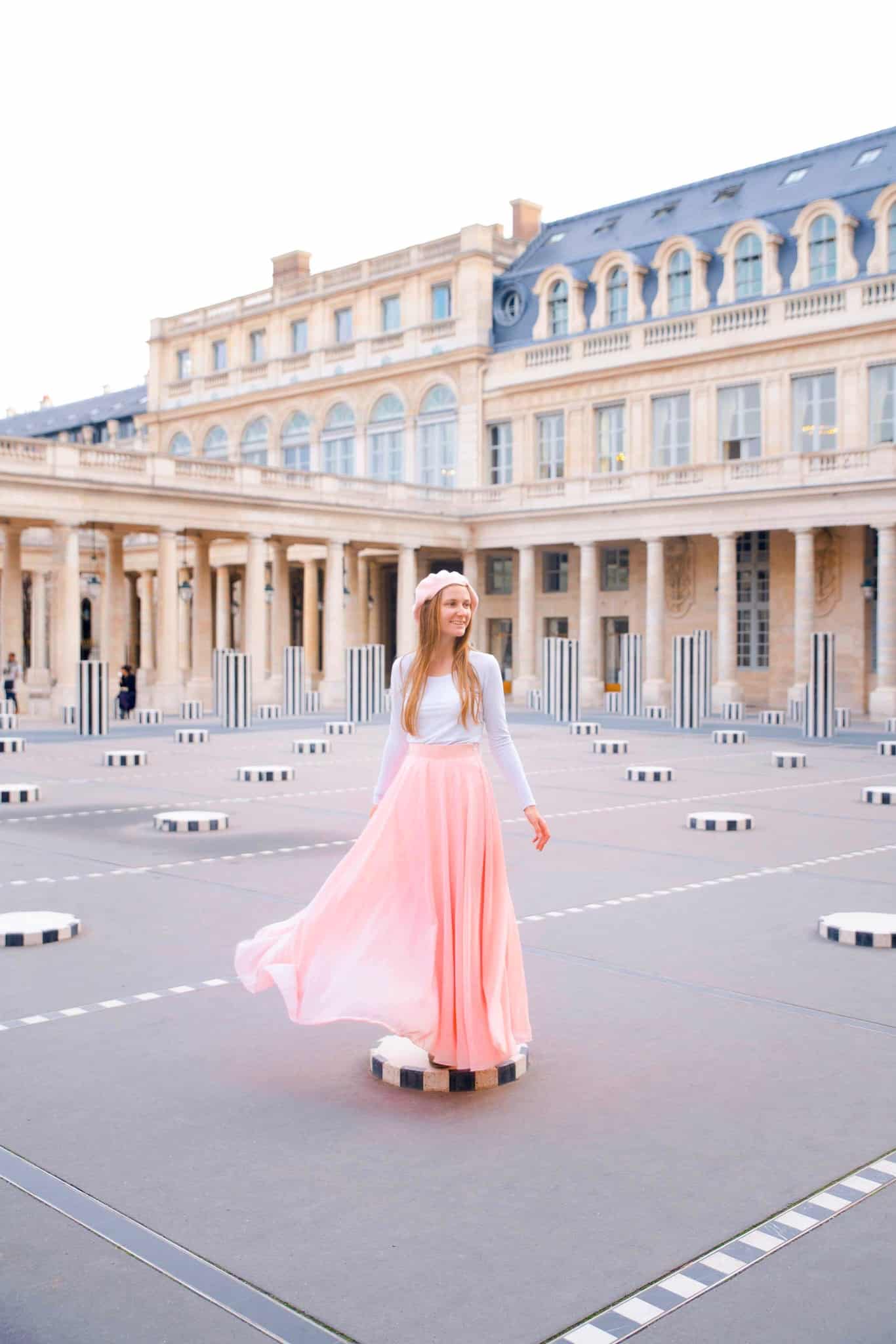 Woman in Pink skirt standing in the Colonnes De Burren Installation.