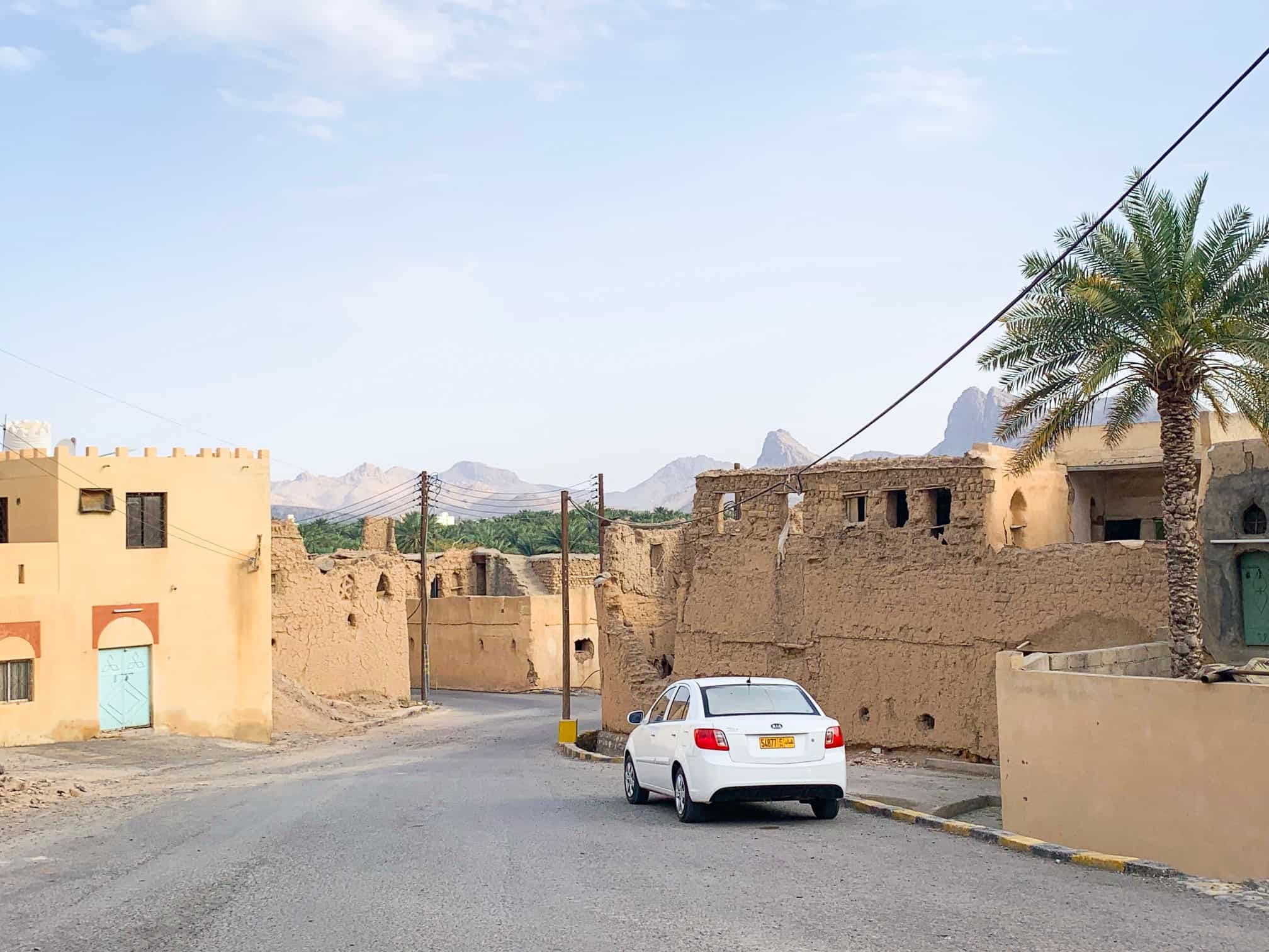 car at the entrance to the Al Hamra ruins in Oman