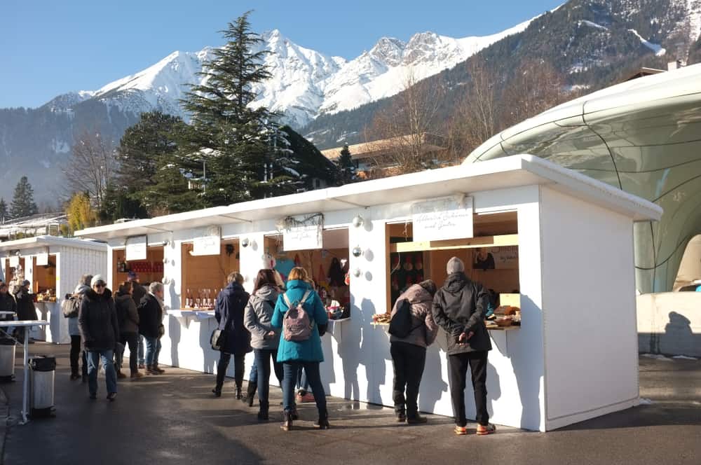 Booths of goods and a view of the alps in Hungerburg Innsbruck, one of the Christmas markets in Austria 