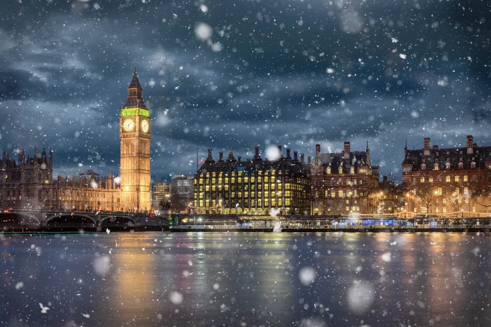 Big Ben over the River Thames at night seen through snowfall.