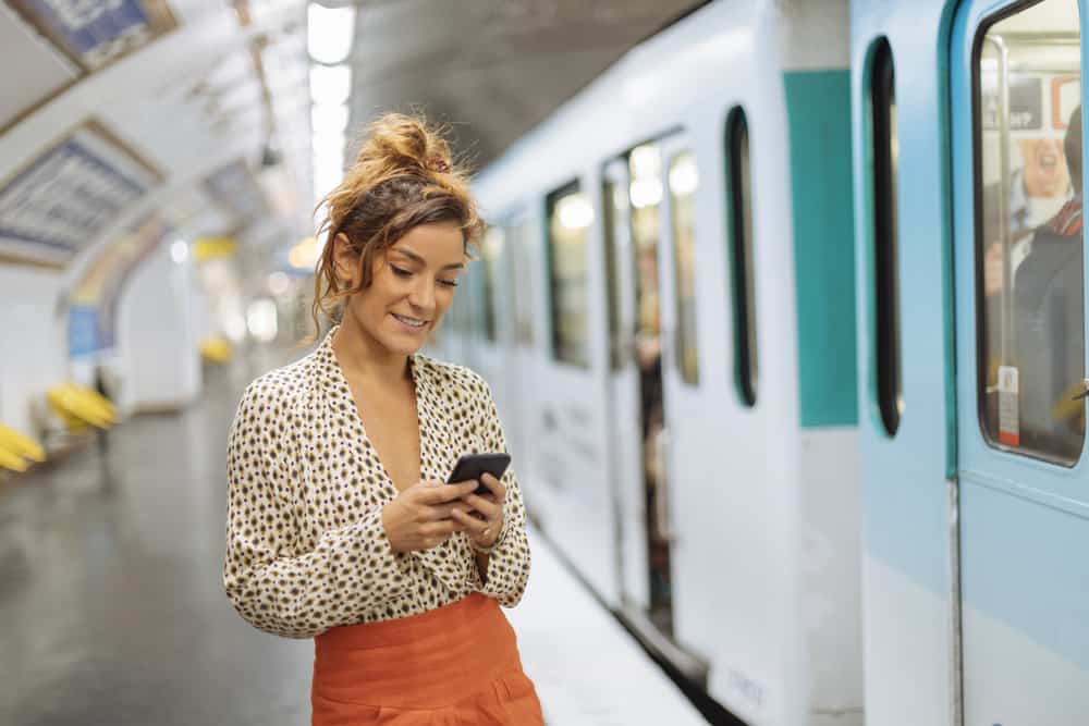 woman on phone using app to get to Paris metro stations