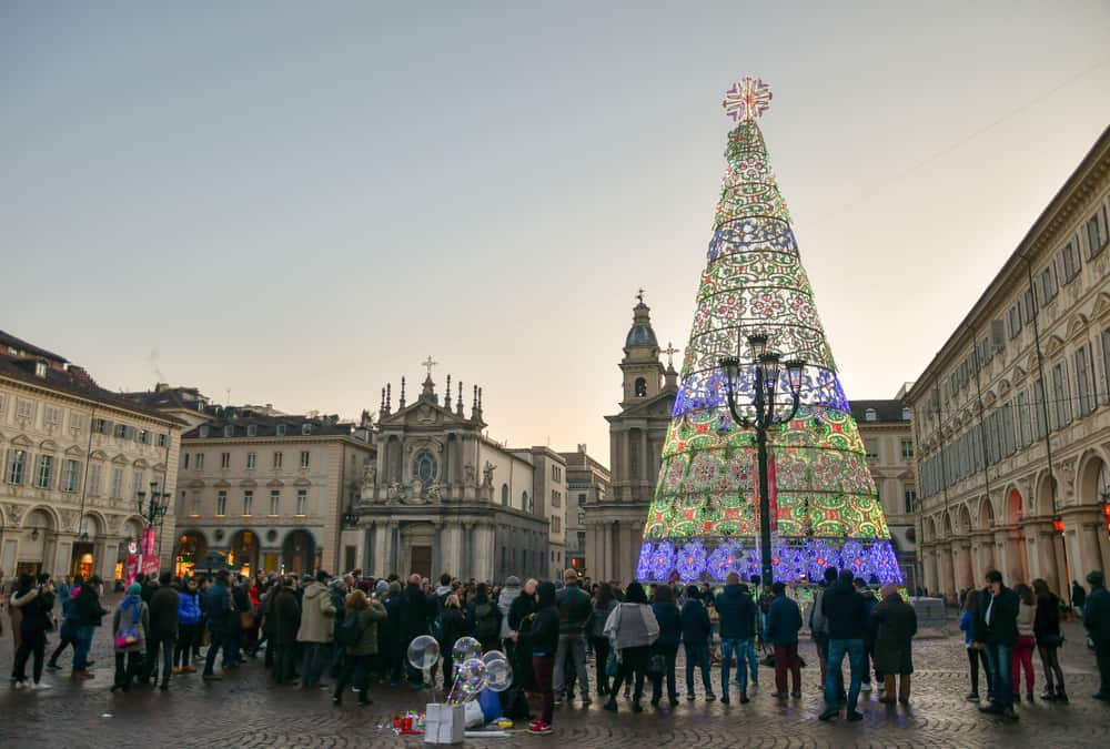 Tourists and locals gather under a lit Christmas tree in Turin, Italy