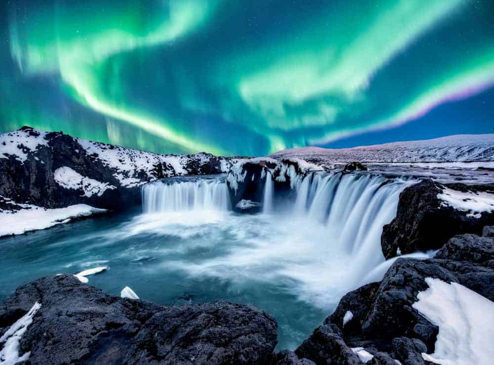 Aurorele boreale deasupra Goðafoss din Islanda în decembrie