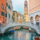 a girl in yellow dress sitting on one of the bridges in Venice