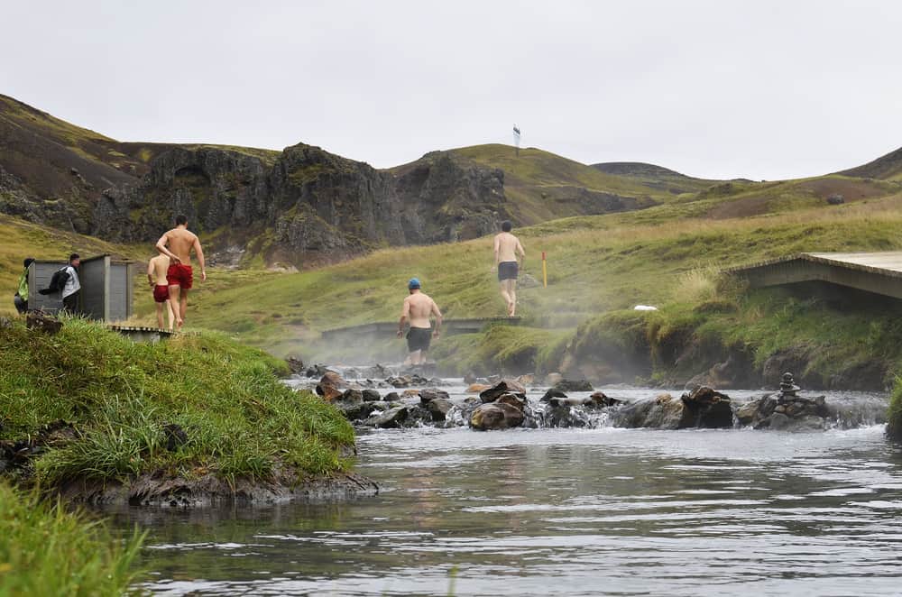 people walk upriver to bathe at Reykjadalur Hot Springs