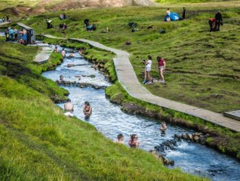 many people bathing in the river at Reykjadalur Hot Springs