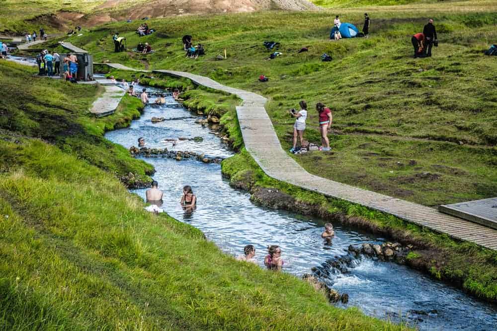 many people bathing in the river at Reykjadalur Hot Springs