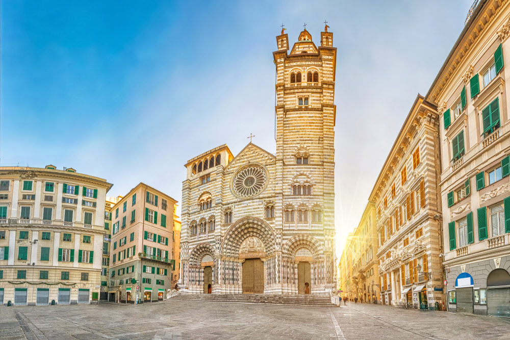 sunrise behind a church in Genoa italy that is located on a piazza square