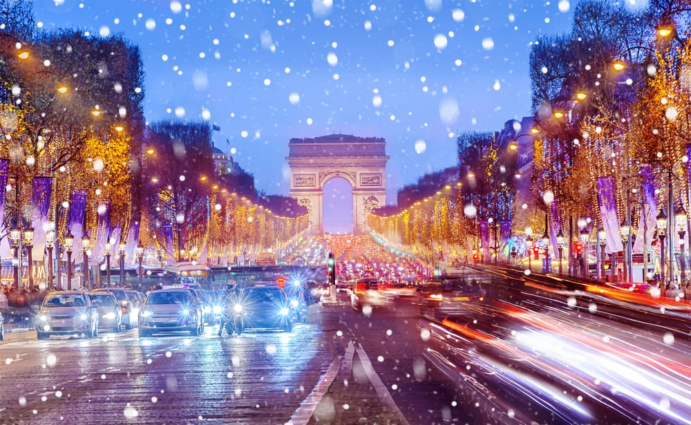 Arc De Triomphe as the snow falls during christmas in paris