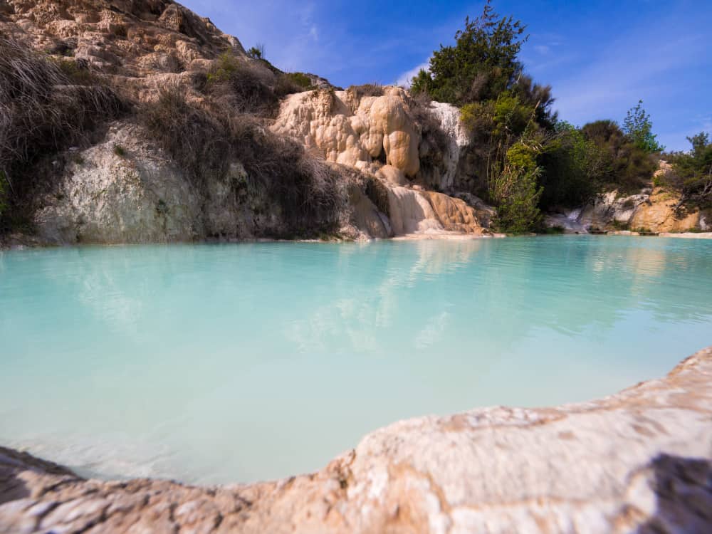 The icy-blue waters and steam of the natural thermal springs make Bagno Vignoni one of the best hot springs to visit!
