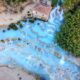 A drone view of the hot springs in Saturnia shows the multiple pools of the thermal springs and the icy blue waters.