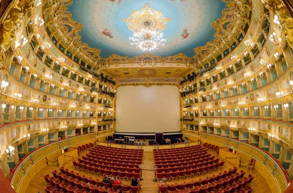 Inside the Teatro La Fenice with painted ceiling and many levels of balconies.