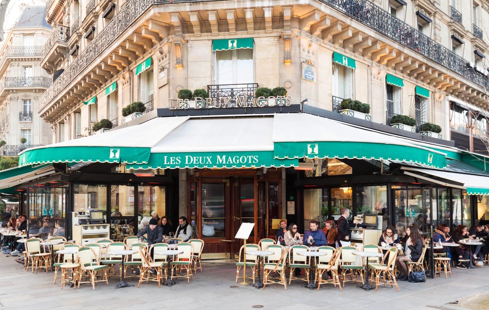 beautiful green cafe in Paris exterior with chairs