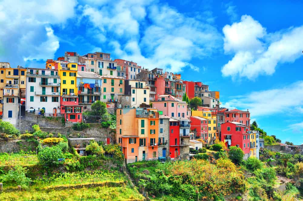 Colorful buildings of Corniglia on a hill on a sunny day.