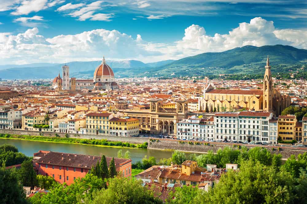 Panoramic view of Florence from across the river with rolling hills in the distance.