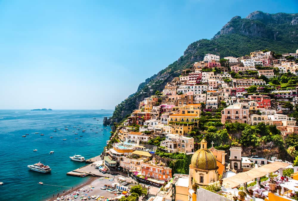 View over Positano with boats in the ocean.