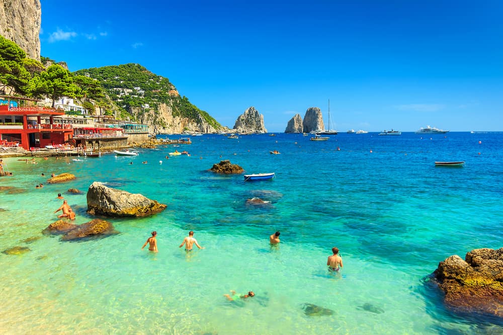 blue waters on the island of Capri one of the best islands in italy with boats in the foreground