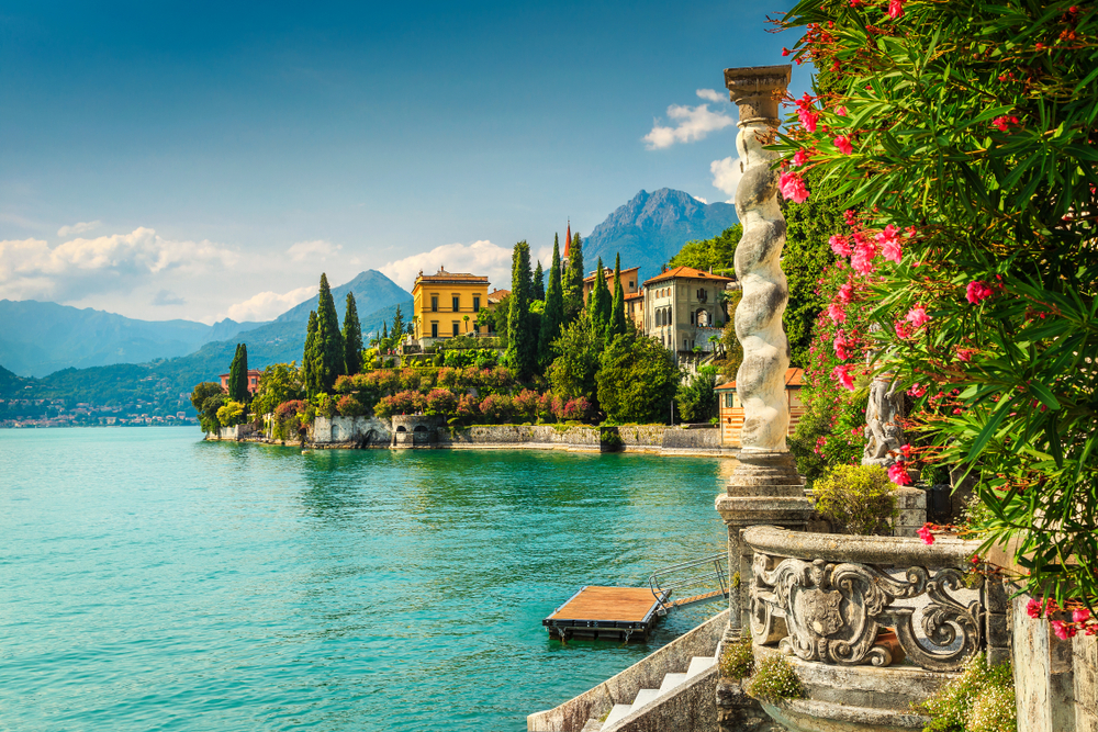Lake Como on a sunny day with flowers in the foreground