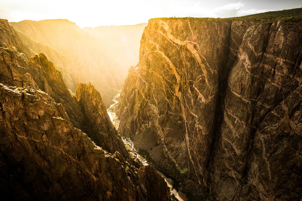 sunset in Black Canyon of the Gunnison National Park with steep cliffs, one of the best stops on a Colorado road trip 