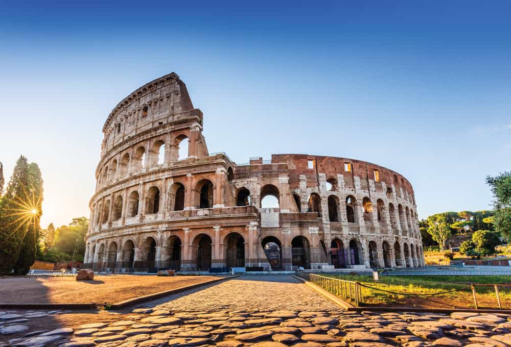 bricks in front of the colosseum in Rome at sunrise with a blue sky