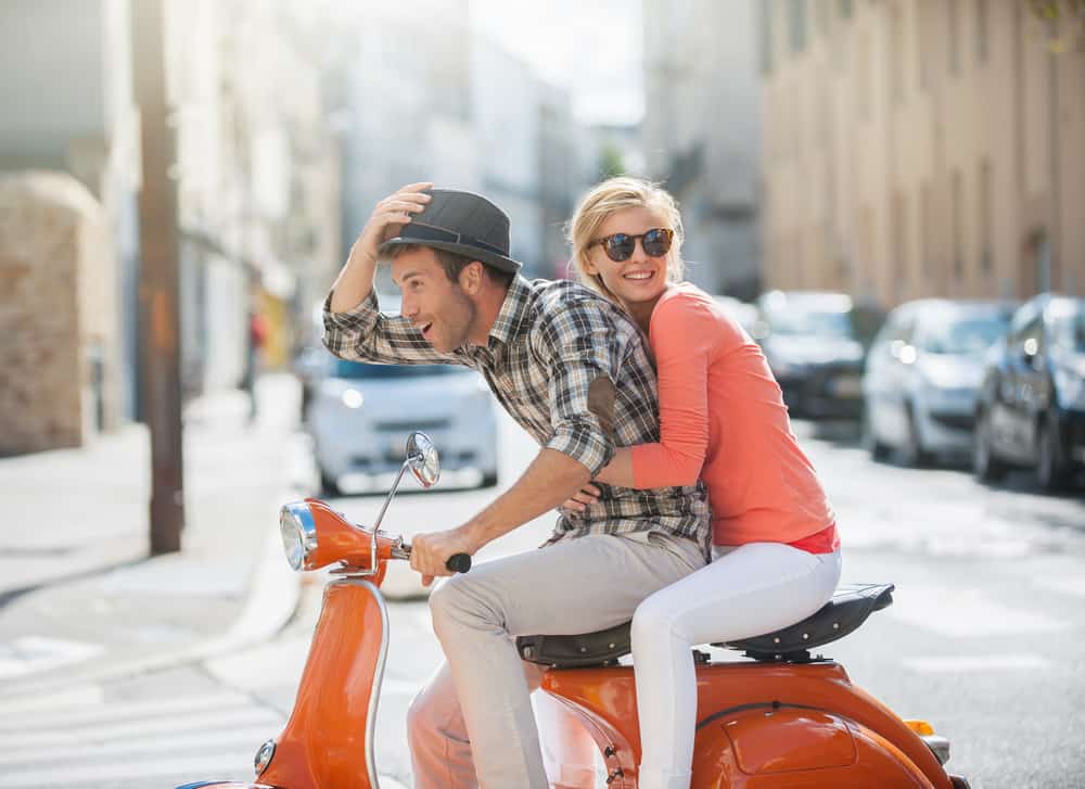 Photo of couple driving in city street.