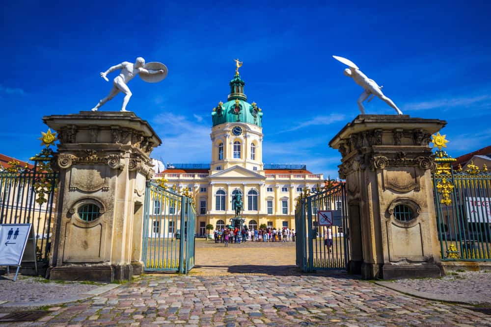 View through a gate with statues to the Charlottenburg Palace.