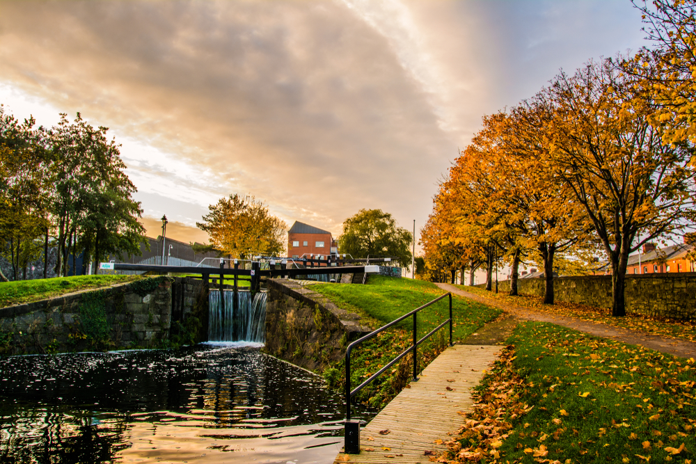 Autumn sunset over the Royal Canal with a small waterfall in the Phibsborough neighborhood, where to stay in Dublin.