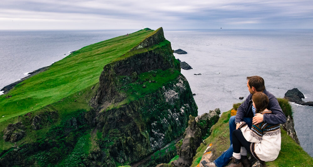 Photo of a couple overlooking cliffs in Ireland.