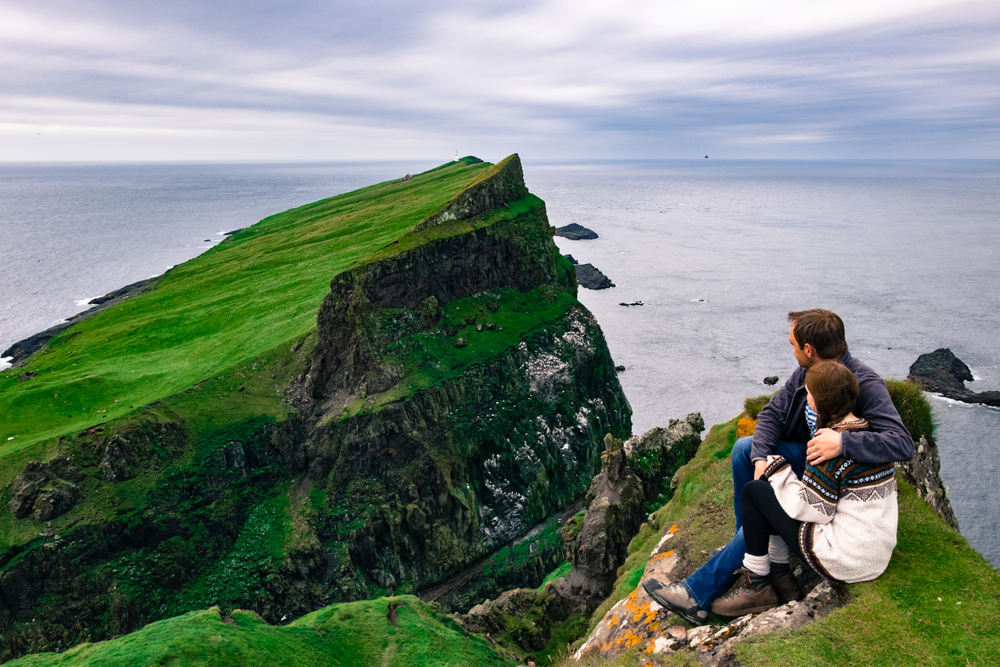 Photo of a couple overlooking cliffs in Ireland.