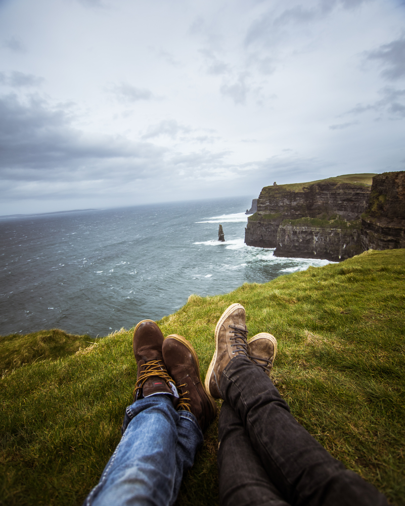 Photo of a couples' shoes, overlooking ocean.