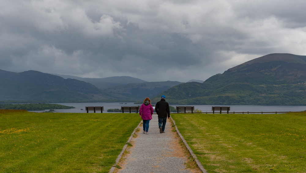 Photo of couple walking down a pathway toward the beach.