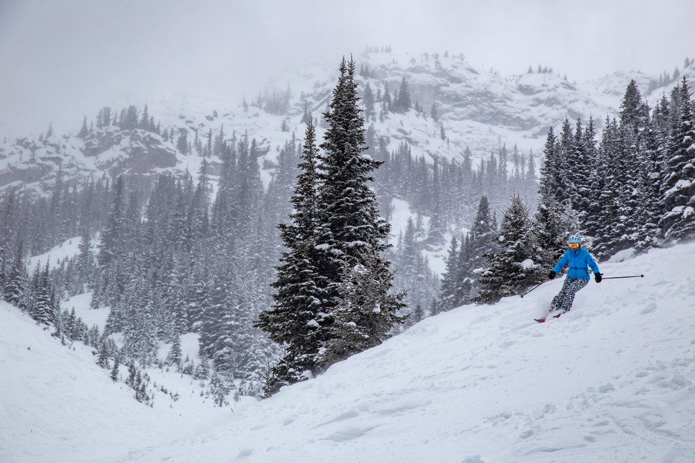 A people skiing on a cloudy day in the mountains.